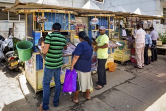 Small street shops with people buying newspapers and magazines, The old market halls of Kandy in