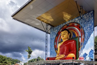 Large Buddha statue under a roof surrounded by rainbow and cloudy sky, Buddha statue in Kandy in