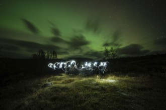 Northern lights, aurora borealis, over lonely log cabin in Dovrefjell-Sunndalsfjella National Park,