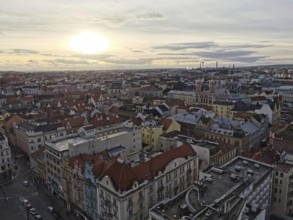 Extensive view of urban rooftops at sunset with industry on the horizon, Pilsen, Czech Republic