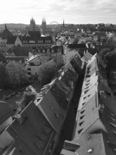 View of an old town with historic buildings, church towers and a Ferris wheel in the background,