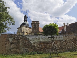 View of an old chapel behind a stone wall on a cloudy day, Czech Republic