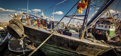 Detailed scene with colorful fishing boats and lively harbor atmosphere when the sun is shining in