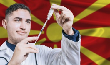 Doctor holding syringe on North Macedonia flag background. Medical professional holding syringe