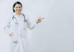 Asian female doctor pointing at medical banner isolated. Young asian female doctor recommending an