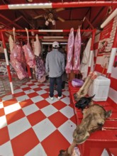 Interior view of a butcher's shop with meat products and striking tile pattern, camel head