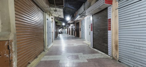 Medina during prayer time in Ramadan, empty, nocturnal alley with closed shops and rolling metal