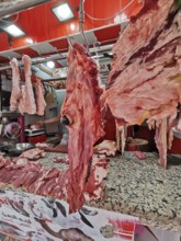 Close-up of pieces of meat and camel's head (camelum) at a lively butcher's stall with red décor,