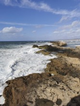 Thundering waves hitting rocky coast under blue sky, Morocco