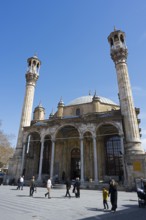 Impressive mosque with minarets against a blue sky with passers-by in the foreground, Aziziye