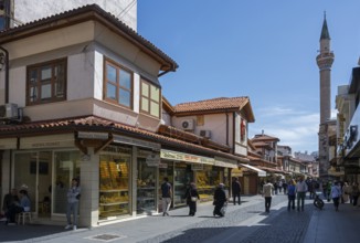 Bustling market street with traditional shops and a minaret in the background, Konya, Central