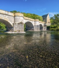 13th century medieval stone bridge across the Werra river, in the back the Liborius chapel,