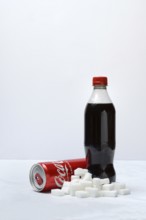 Cola drink in bottle and can, lots of sugar cubes