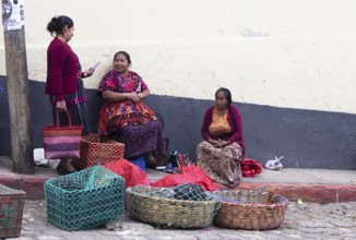 Mayan woman wearing traditional clothing sell chickens on the street in Chichicastenango,