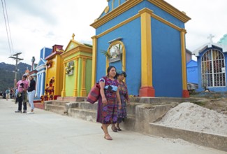 Mayan woman wearing traditional clothing at colorful graves at the cemetery in Chichicastenango,
