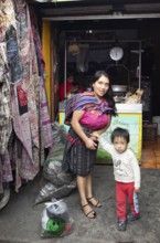 Mayan woman with toddler in traditional clothes at the market in Chichicastenango, Highlands, El