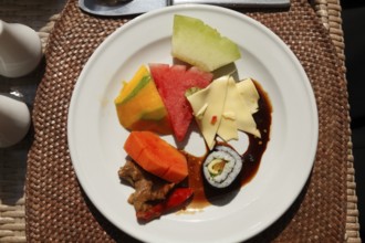Rich Asian breakfast at the hotel with fruits and vegetables, Ubud, Bali, Indonesia