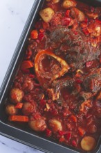 Ossobuco stew with vegetables, knuckle on the bone with new potatoes, in tomato sauce, homemade,