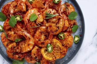 Grilled shrimp, unpeeled, headless, with spices, on a marble table, homemade, no people