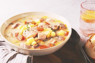 A bowl of soup on a light background, Finnish fish soup, lohikeito soup, creamy fish soup