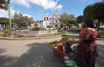 Parque Centroamérica or Parque Central, a Mayan woman in traditional dress selling oranges, in the
