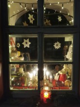 A festively decorated window with lights and Christmas decorations in a cozy atmosphere, Franconian