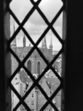 View of church towers and urban architecture through a lattice window, Gdansk, Poland