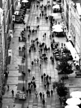 Black and white aerial view of a busy pedestrian zone with numerous passers-by and cafés, Gdansk,