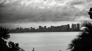 View across the sea to a distant skyline under a cloudy sky, Batumi, Georgia