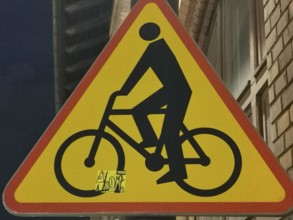 Traffic warning sign with a black bicycle symbol on a red triangle, Poland