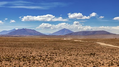 Wide desert landscape with distant mountains and slightly cloudy sky, The landscape of the