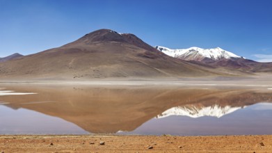 Lonely mountain landscape reflected in the still, clear water of a lake, Laguna Colorada in the