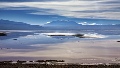 Dramatic cloud formations over a reflecting lake and distant mountain ranges, The Laguna Colorada
