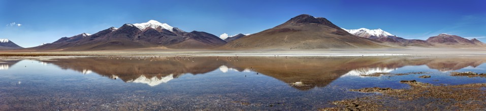 Wide panoramic view of mountains reflecting in the still lake, with snow-capped peaks, The Laguna
