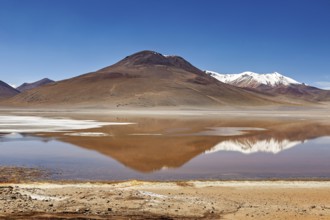 Lonely mountain landscape with reflecting lake and snow-capped peaks under clear skies, Laguna
