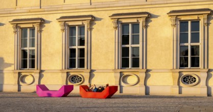 Pink and red plastic furniture for sitting and lying in front of the Humboldt Forum, Berlin,