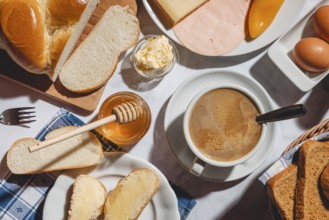 Breakfast, stollen with butter and honey, surrounded by cheese, ham, coffee, peppers and eggs