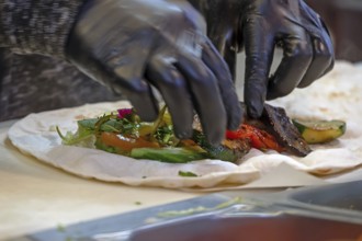 Preparation of falafel with fresh vegetables in a falafel stand in the pedestrian zone, Nuremberg,