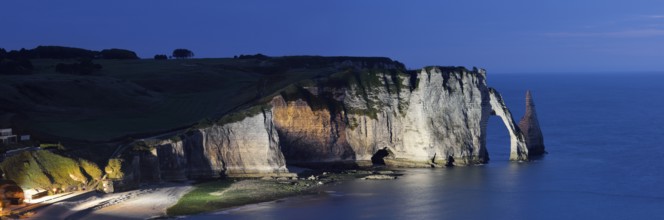 Cliff with the Falaise d'Aval rock gate and the Aiguille d'Etretat rock pin at night, Etretat,