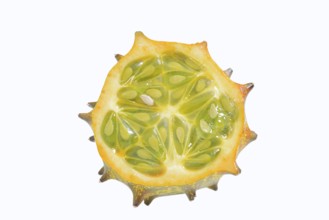 Horned cucumber, kiwano or horned melon (Cucumis metuliferus), sliced fruit on a white background,