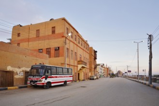 Bus parked on a street and houses, Esna, Egypt