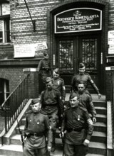 Two Soviet soldiers in front of the administration of the war commander for the district of