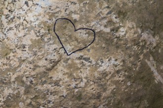 Close-up of painted black heart outline symbol on tanned nuanced rock surface, Quebec, Canada