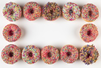 Donut frame with colorful sprinkles on white background
