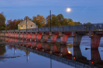 Illuminated Moulin Neuf water flow control dam and walkway over Des Mille-Iles river plus New Mill