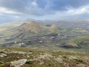 View of Montaña Tesa volcano from Montaña Blanca mountain with cloudy sky, Lanzarote, Canary