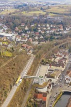 Panorama of city with railroad tracks, hills and river, surrounded by dense residential