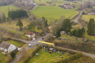 Rural landscape with individual houses, fields and a yellow train on the tracks, acceptance of the