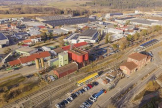 Aerial view of an industrial landscape with yellow train and various buildings, acceptance of the