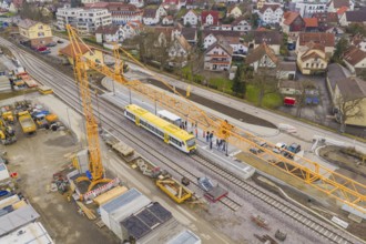 Aerial view of a yellow train on a construction site, crane and workers during construction, the